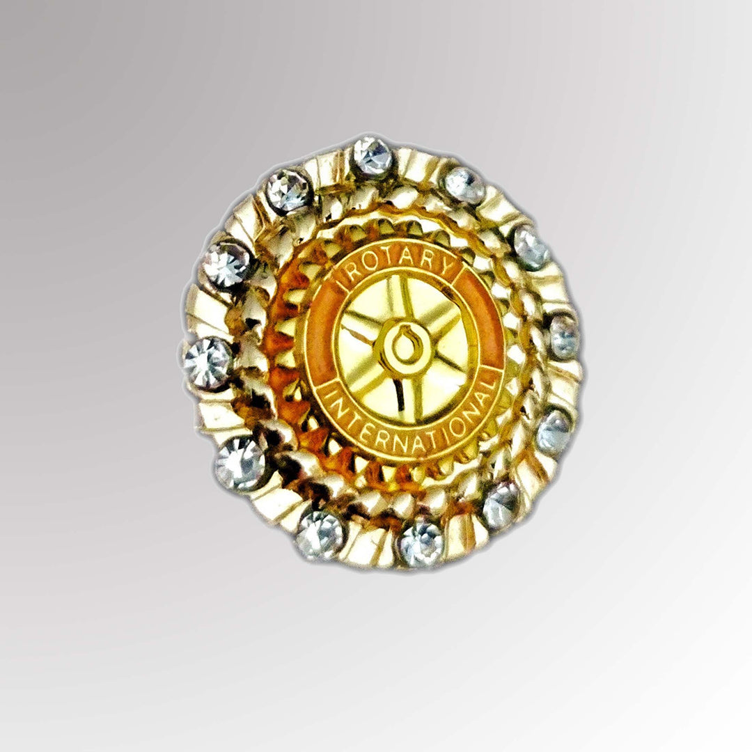 A polished metal Fancy Member Pin featuring Rotary International's Mark of Excellence logo with white-colored imitation stones.