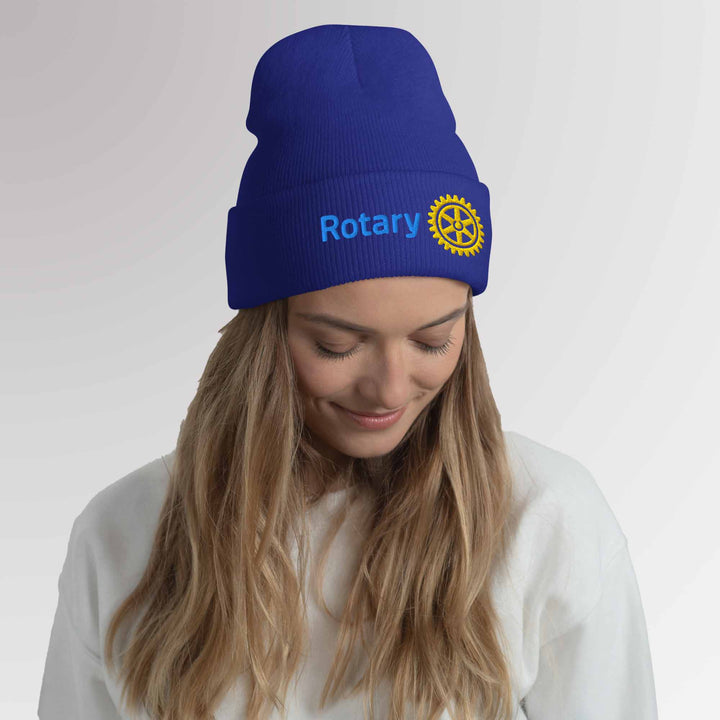 Female model wearing a high-quality blue cuffed beanie with the Rotary International Master Brand logo embroidered, combining comfort and sophistication