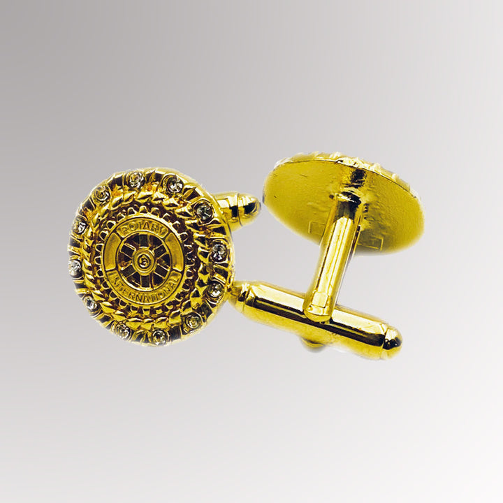 A pair of gold-plated Rotary Cuff Links with white imitation stones featuring Rotary International's Mark of Excellence logo.