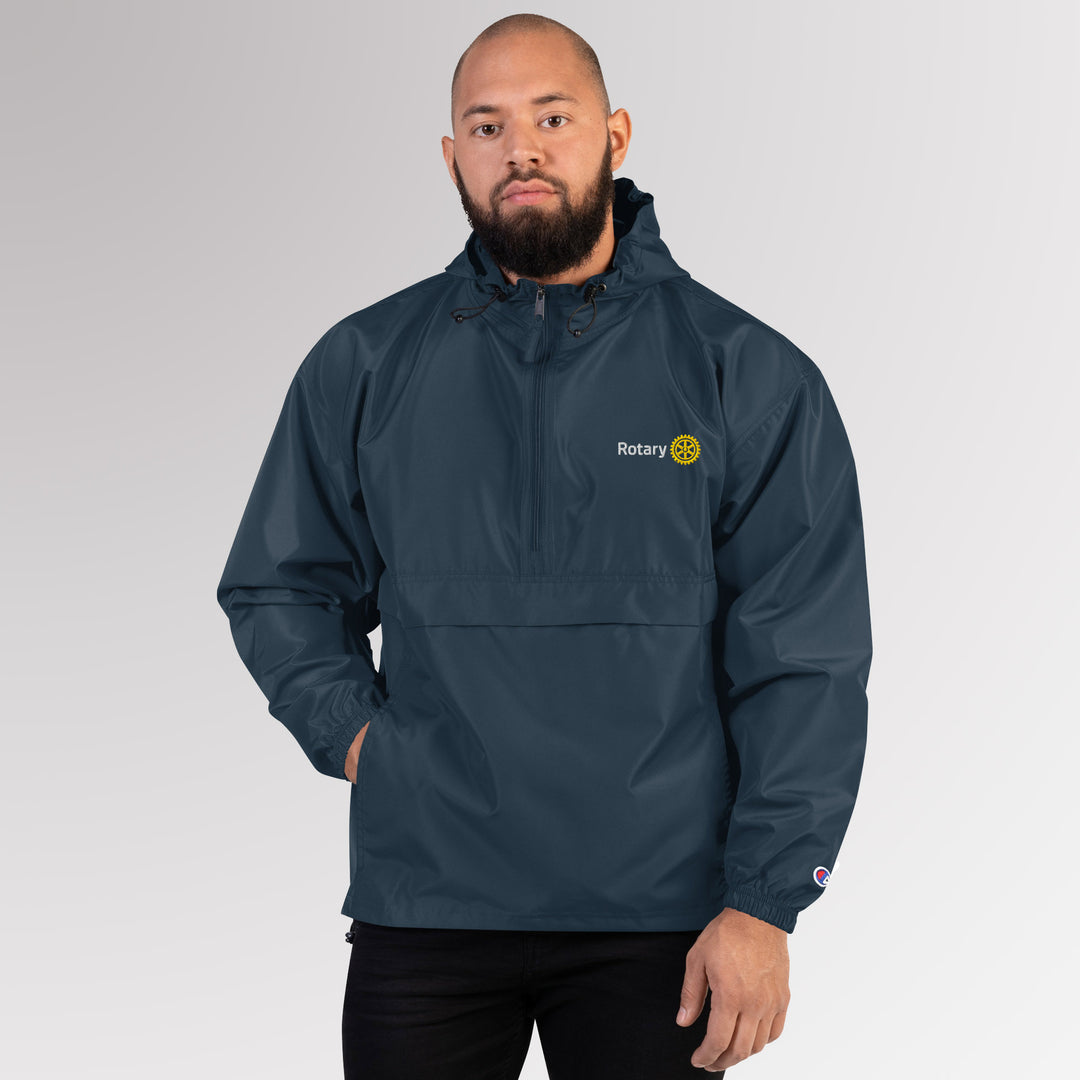 Front view of a man wearing a navy Champion packable jacket embroidered with the simplified Rotary Masterbrand logo on the chest.