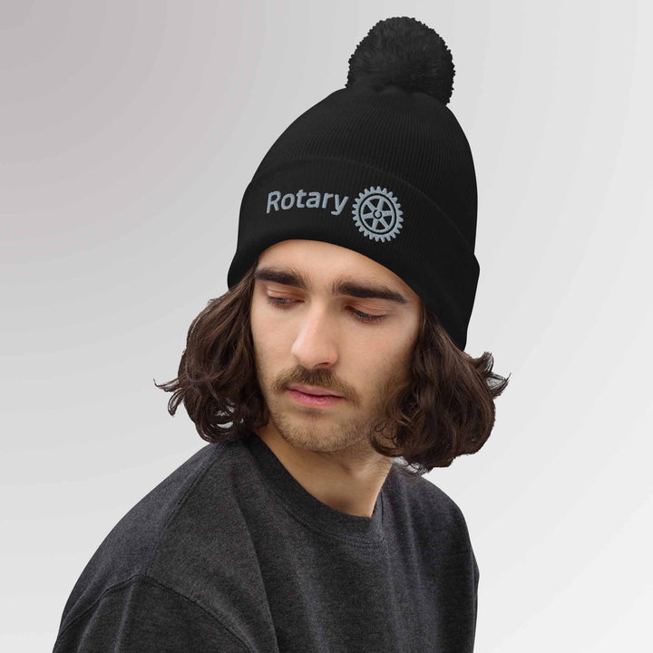 Male model showcasing a high-quality black beanie featuring the Rotary International Master Brand logo embroidered, ideal for everyday wear.