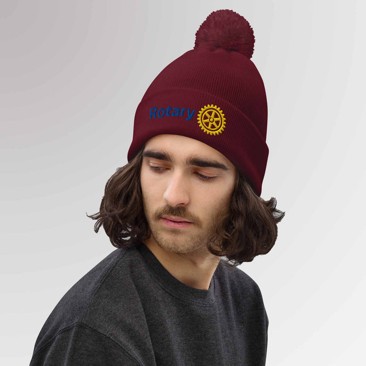 Male model showcasing a high-quality blue cuffed beanie featuring the Rotary International Master Brand logo embroidered, ideal for casual and Rotary events