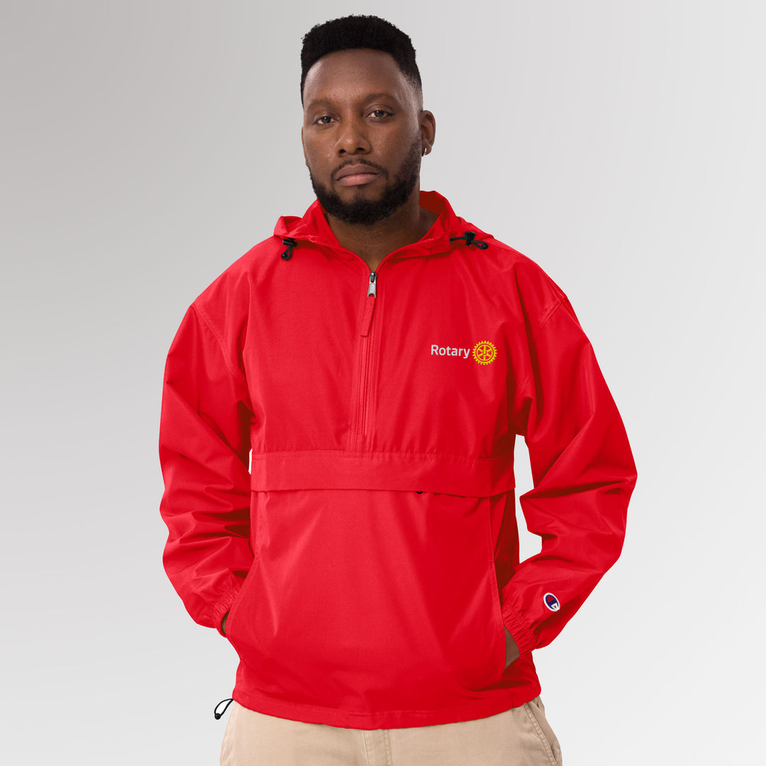 Front view of a man wearing a red Champion packable jacket embroidered with the simplified Rotary Masterbrand logo on the chest.