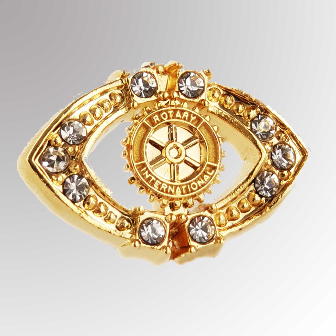 A gold-plated Fancy Stone Pin featuring Rotary International's Mark of Excellence logo with white imitation stones.