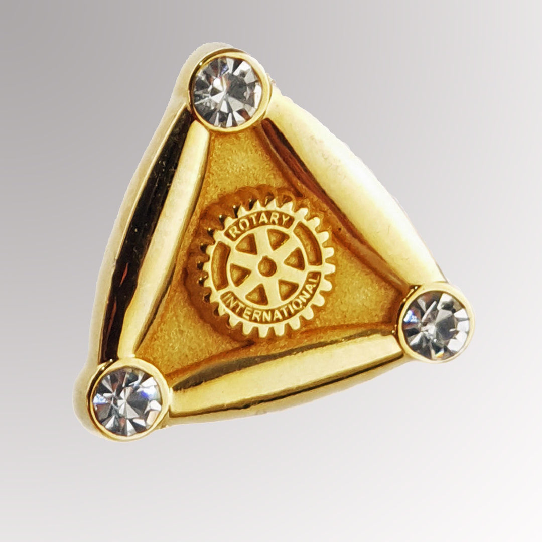 A gold-plated Special 3-Stone Pin with a matte background featuring the Rotary Mark of Excellence and three white imitation stones.