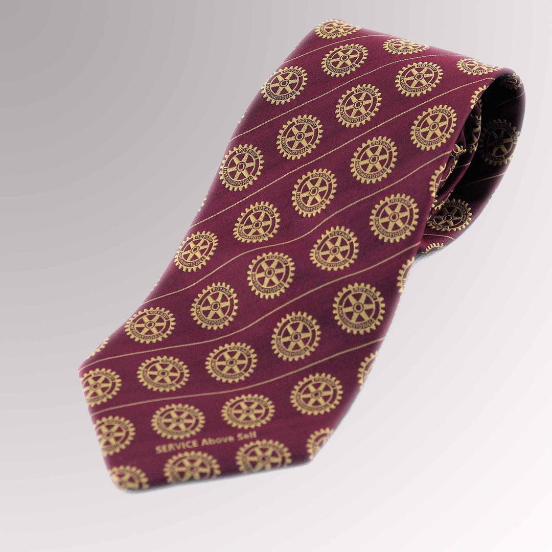 A woven silk tie with a maroon background featuring Rotary International's Gold Mark of Excellence.