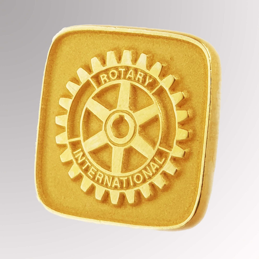 A gold-plated Rotary Member Pin with a matte background featuring the Rotary Mark of Excellence logo.