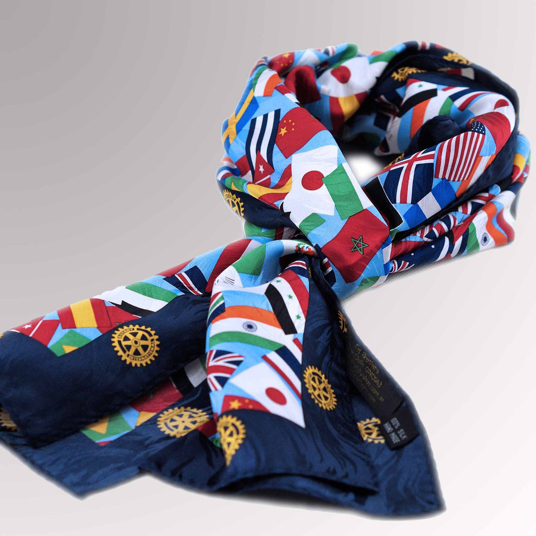 A high-quality silk scarf with a blue border, featuring multi-national flags and the Rotary Mark of Excellence logo.