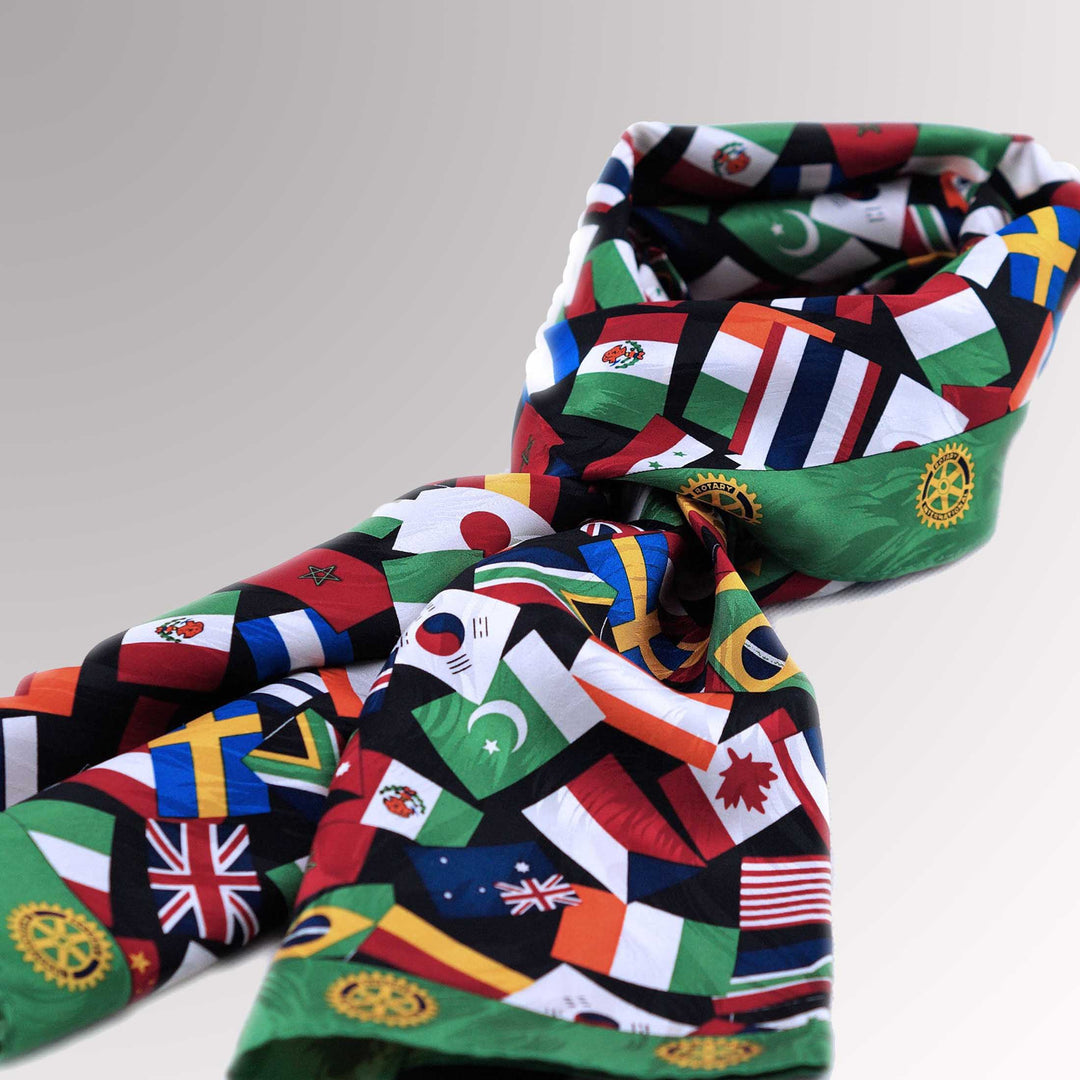 A high-quality silk scarf with a green border, featuring multi-national flags and the Rotary Mark of Excellence logo.