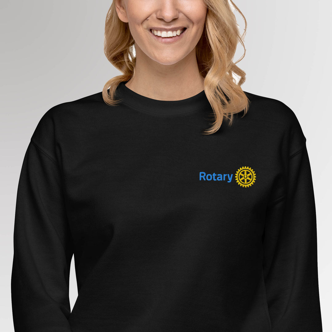 Female model wearing the black colored  high-quality premium sweatshirt featuring the embroidered Rotary International Master Brand logo by Awards California