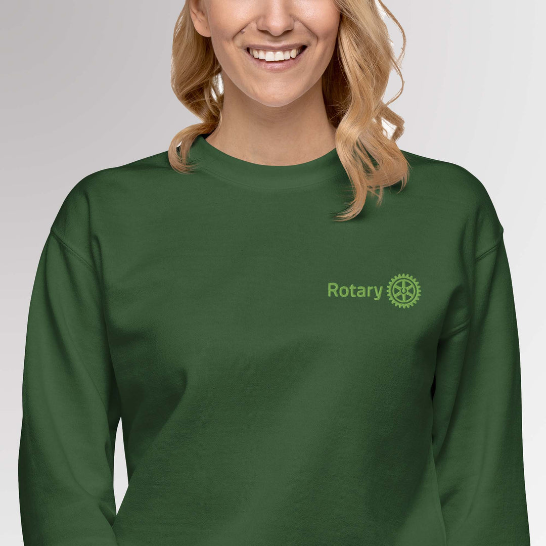 Female model wearing forest green colored high-quality premium sweatshirt featuring the embroidered Rotary International Master Brand logo by Awards California